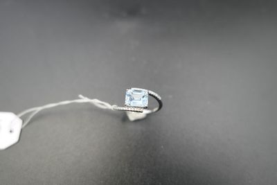 une image représentant une bague sertie d'une topaze bleue sur un fond noir