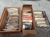 deux cartons remplis de papiers, posés au bord d'une rue
