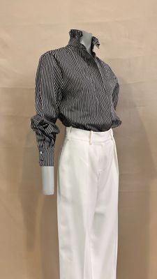 a mannequin wearing a black and white striped shirt and white pants