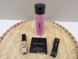 a bottle of liquid, mascara, and mascara brush on a tray