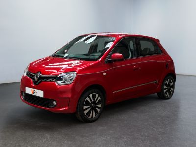 Une voiture rouge est garée dans une pièce aux murs blancs