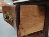 a close up of a wooden dresser with a marble top