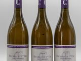 trois bouteilles de vin posées sur une table blanche
