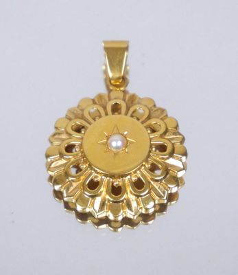 an image of a gold pendant with a pearl in the center