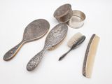 trois brosses, un peigne et une brosse posés sur une surface blanche