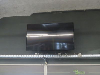 a flat screen tv mounted on the ceiling of a garage