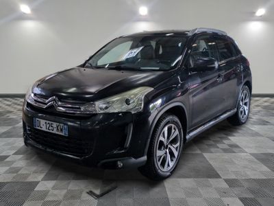 la voiture noire est garée sur un sol en damier dans le garage