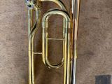 an old brass instrument sitting on top of a piece of luggage