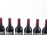 six bottles of wine are lined up in a row on a table
