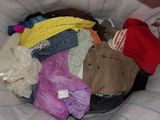 a pile of clothes in a basket on a bed