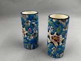 deux vases bleus ornés de motifs floraux, posés sur une table