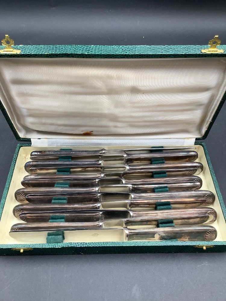 Lot de 12 couteaux modèle coquilles, lames inox et manches en métal argenté. Bon état d’usage, présentés dans un écrin.
