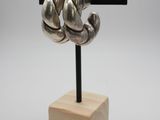 a metal sculpture of a pair of hands on a wooden stand