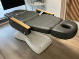 un gros plan d'un fauteuil de massage noir et blanc posé sur un parquet