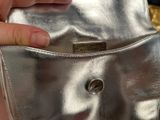 a person holding a silver purse in their hand