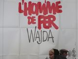 affiche de cinéma représentant un homme et une femme marchant devant une foule de gens