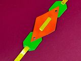 a paper kite with a green and orange design on it
