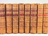 plusieurs vieux livres sont alignés sur une surface blanche