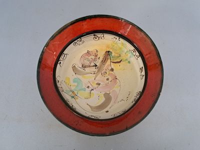 a red plate with a picture of a man riding a horse on it