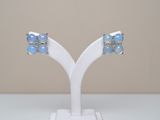 a pair of oplite and diamond earrings on a white stand