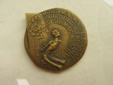 une vieille médaille en bronze représentant une femme tenant une épée