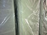 many mattresses lined up in a warehouse with plastic covering
