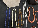 several necklaces and bracelets are displayed on a table