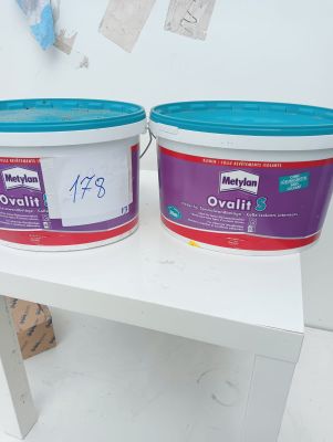 two buckets of paint sitting on a white table