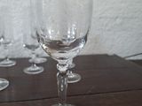 several empty wine glasses sitting on a wooden table in front of a white wall