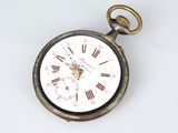 a pocket watch that is sitting on a white surface