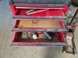 une boîte à outils rouge avec des outils sur le sol