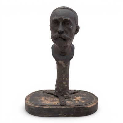 statue of a man ' s head on a wooden base