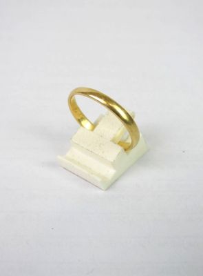 une bague en or posée sur un bloc de marbre blanc