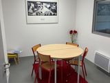 une table et des chaises dans une pièce où il y a un tableau accroché au mur