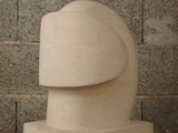 a sculpture of a head on a table in front of a brick wall