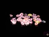 some pink and yellow diamonds are on a black surface
