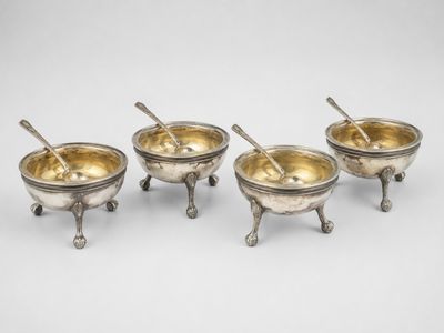 un ensemble de quatre bols en métal argenté avec cuillères sur socles