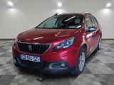 la voiture rouge est garée sur un sol en damier dans le garage