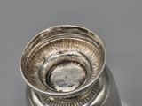 a silver vase that is sitting on a table