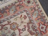 rug on the floor with fringes on top of it and a cat laying on the floor