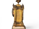 a gold clock that is sitting on a white surface