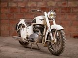a white motorcycle that is parked in front of a brick wall