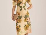 une femme vêtue d'une robe jaune à fleurs prend la pose pour une photo