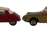 deux voitures jouets assises l'une à côté de l'autre sur une surface blanche