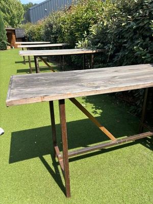 two wooden tables sitting on the grass in the yard