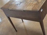 a wooden table with a drawer on it in a room