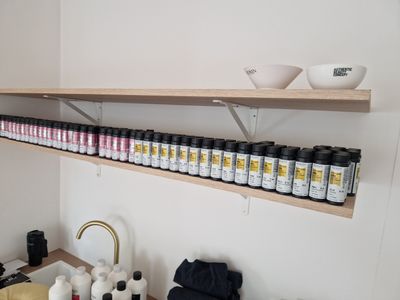 a shelf that has many bottles of paint on it