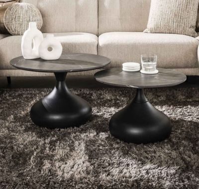 two tables that are sitting on a rug in a living room