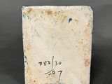 a close up of a small ceramic block with writing on it