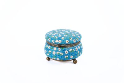 petite boîte recouverte d'un motif floral bleu et blanc, posée sur une surface blanche